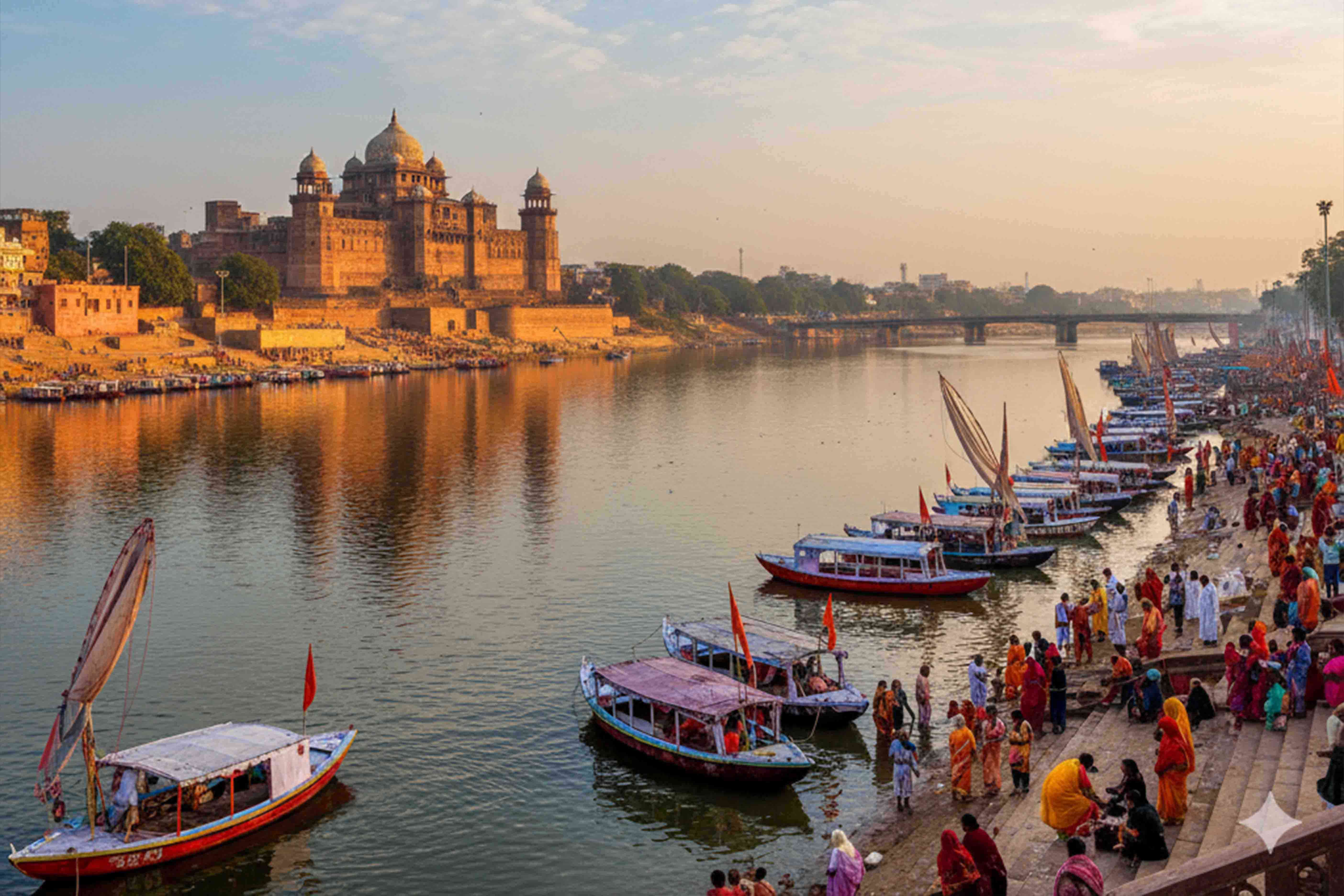 Panoramic view of Prayagraj, India, with boats on a river and historic buildings along the bank.